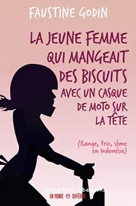 La jeune femme qui mangeait des biscuits avec un casque de moto sur la tête